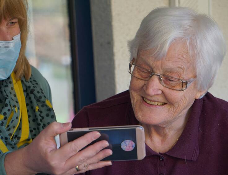 femme montrant un téléphone à une autre femme